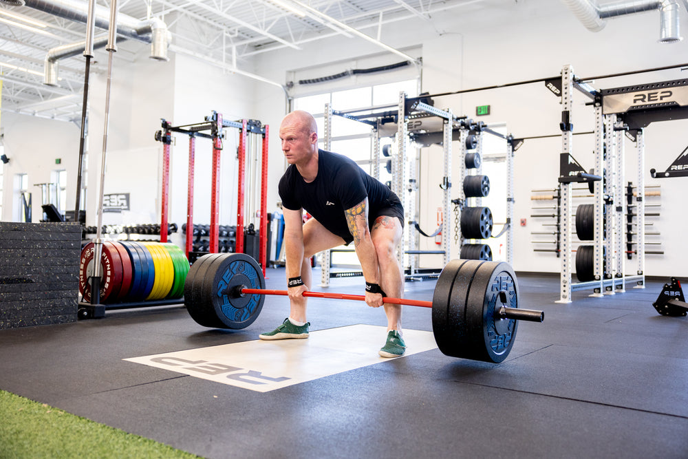 Lifter performing a deadlift while wearing REP Lifting Straps..