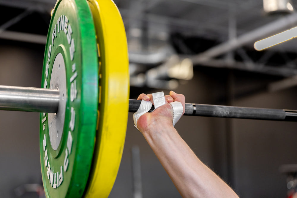 Close-up view of the right-sided white REP Olympic Lifting Strap at the finish position of a snatch.