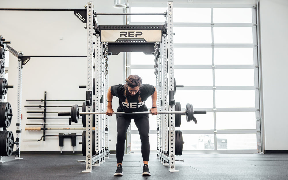 Female lifter performing a bent over row with a loaded REP Mesa Technique Bar.