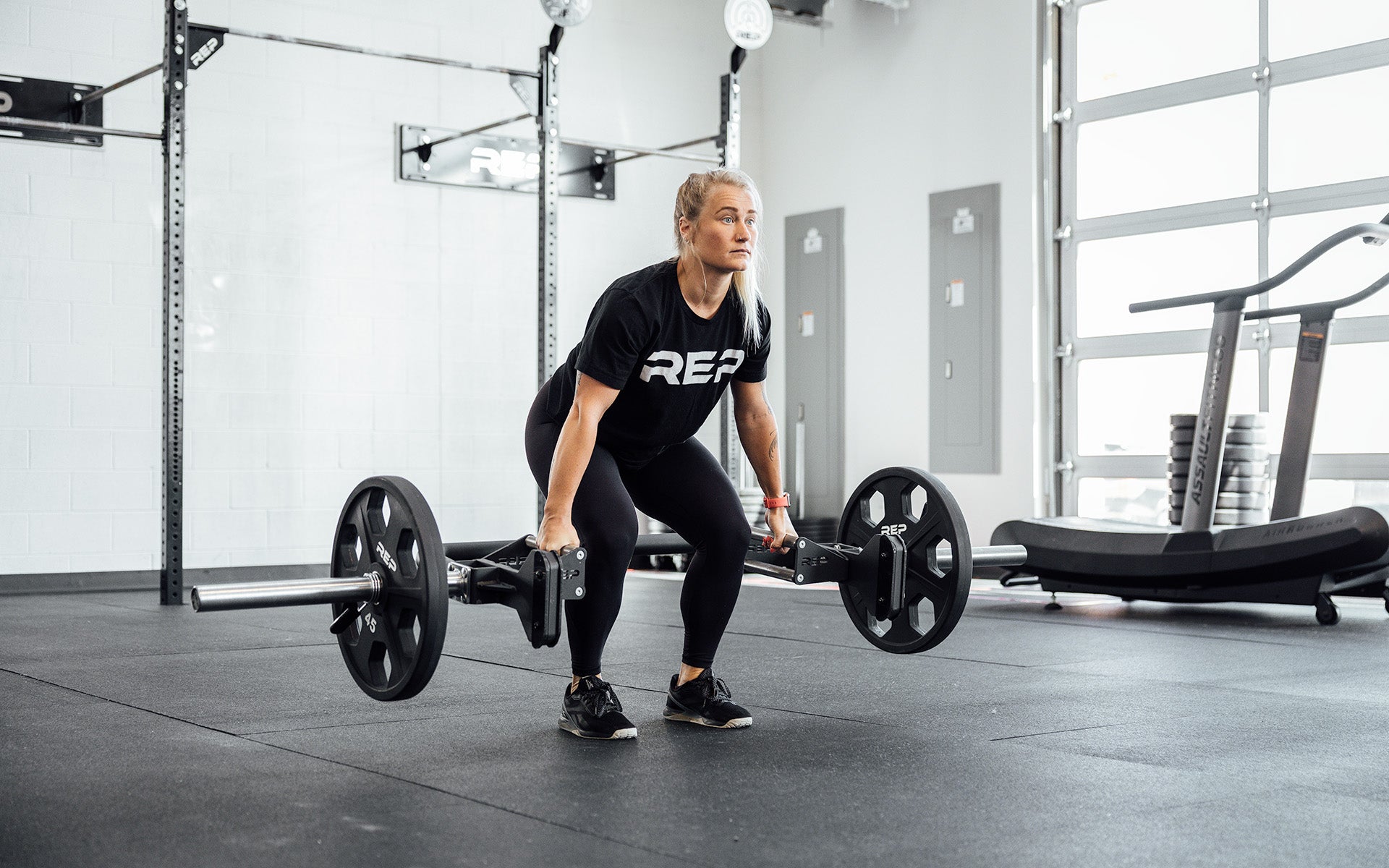 Female athlete performing a deadlift with the REP Open Trap Bar.