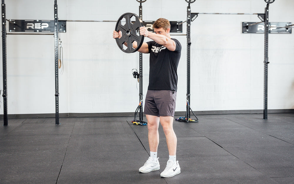 Lifter using a single 45lb USA-Made Equalizer Iron Plate for front shoulder raises.