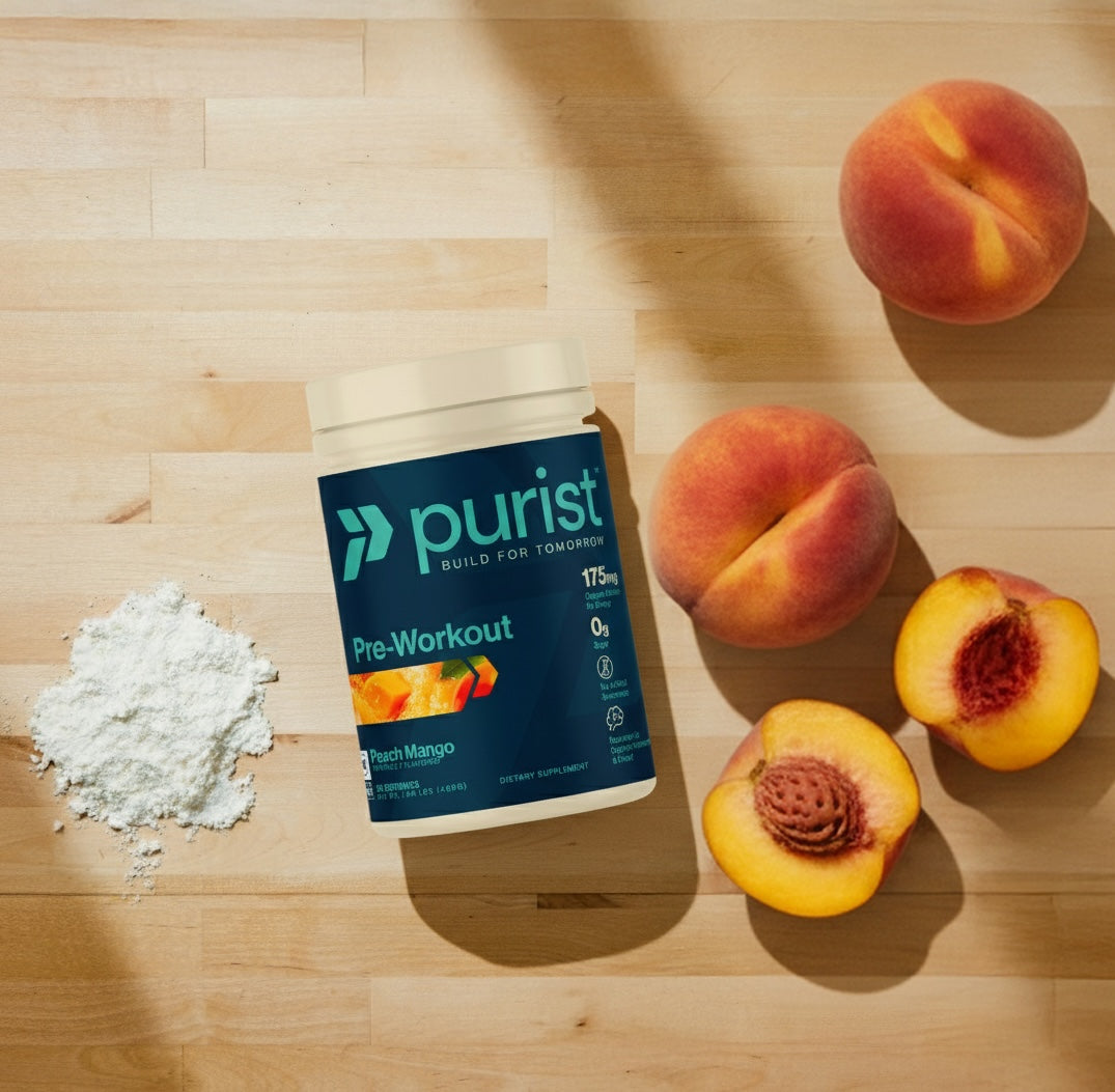 Purist® peach mango pre-workout supplement container with peaches on a wooden surface