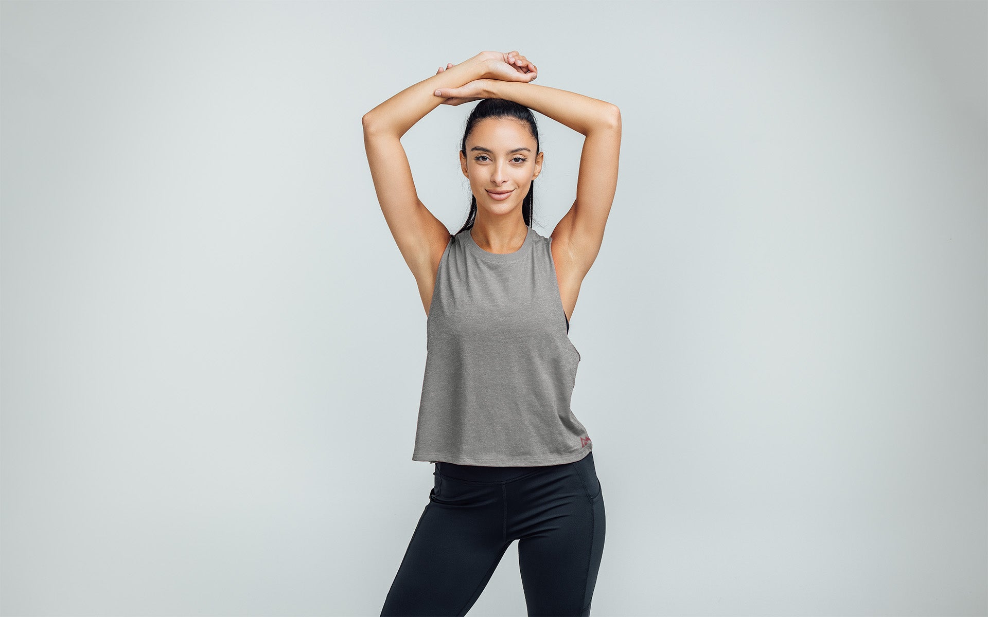 Woman wearing Heather Gray/Mauve Peak Cropped Dual-Blend Tank - Arms up