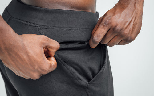 Close-up view of model closing the zipper to the hip pocket of his REP Attis Shorts.