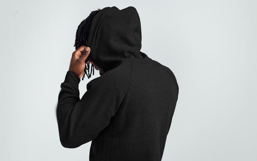 Man wearing Black/White Unisex Zip Hoodie - Back view, hood up