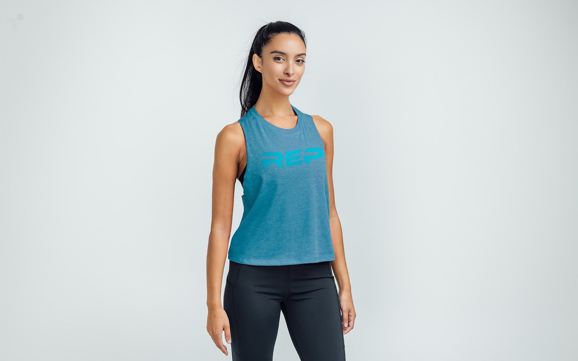 Woman wearing Heather Teal/Teal Daily Driver Cropped Dual-Blend Tank