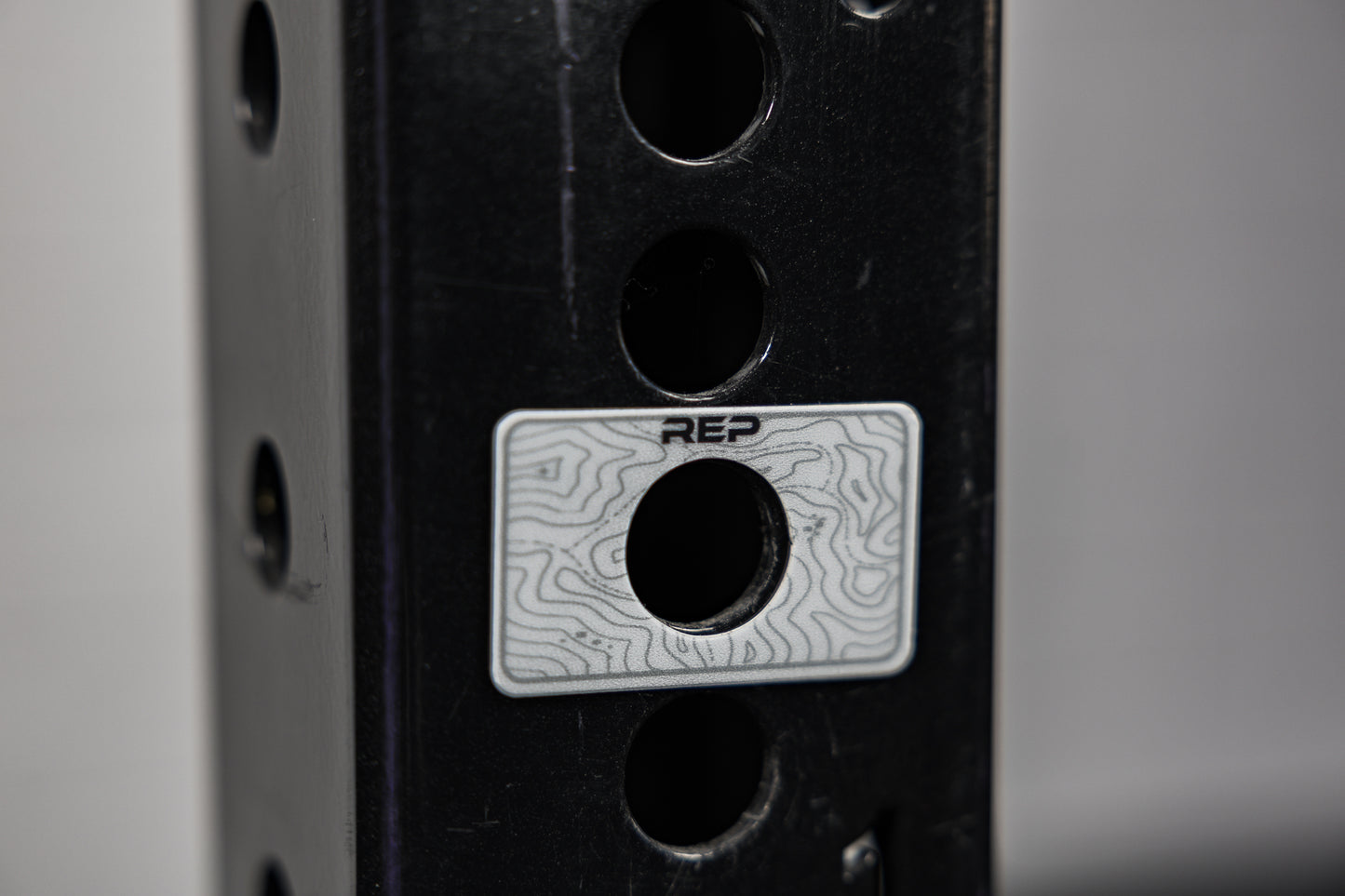 A blank Power Rack Magnetic Position Marker over a bench zone hole on a 4000 series rack upright
