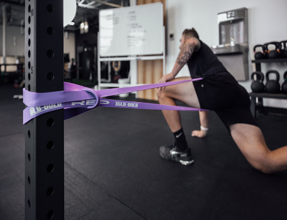 Athlete stretching with a purple Latex-Free Pull-Up Band.