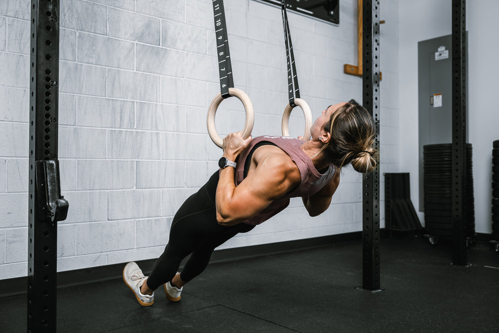 Athlete doing rows on REP Competition Gymnastic Straps and Wood Rings from a REP Wall-mounted Rig