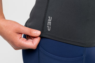 Close-up view of the flatlock stitching and "REP" logo on the Women's Clio Tank Top.