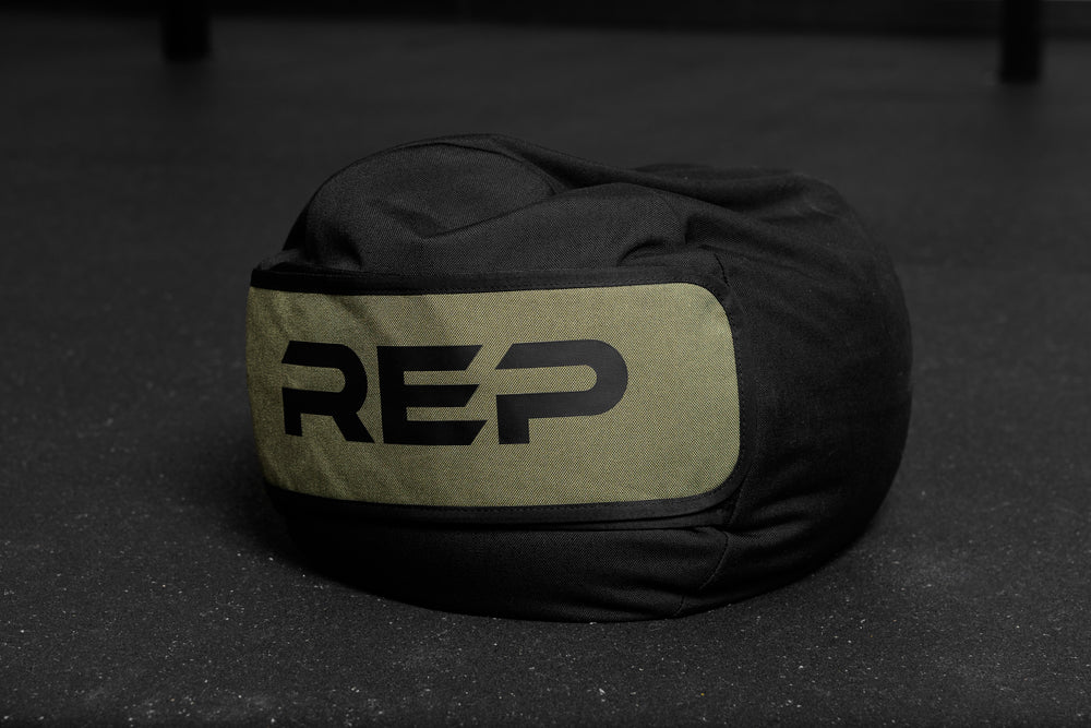 Black and green stone sandbag with 'REP' branding on a dark surface