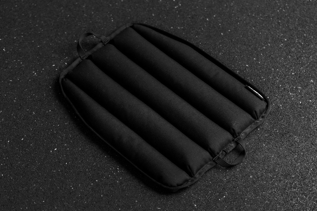 Black soft weight vest plate with ribbed texture on a dark textured background