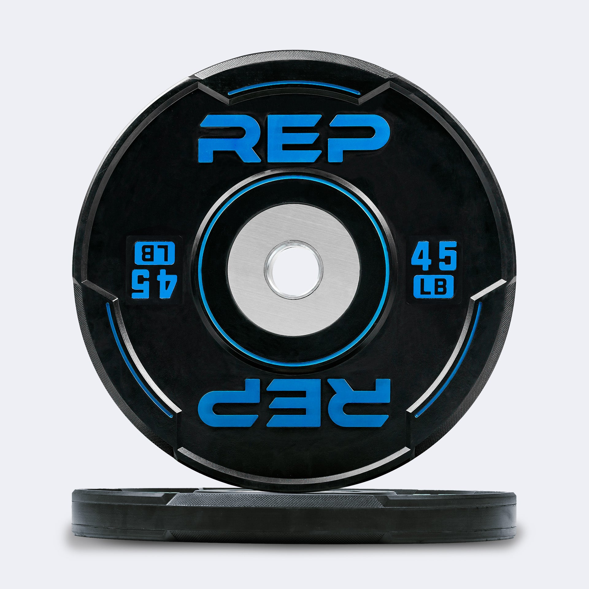 Studio-shot: Front and side profile of a blue 45 lb REP Sport Bumper Plate 2.0 on a white background