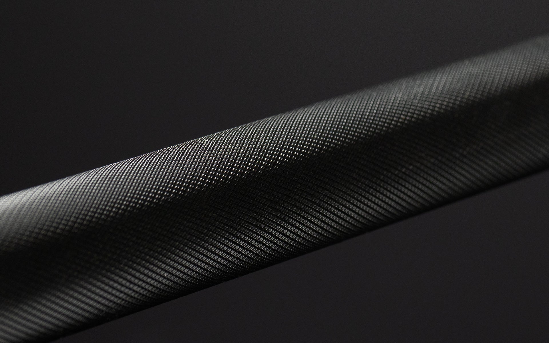 Close-up view of the knurling on a black chrome REP Teton Training Bar - 20kg.