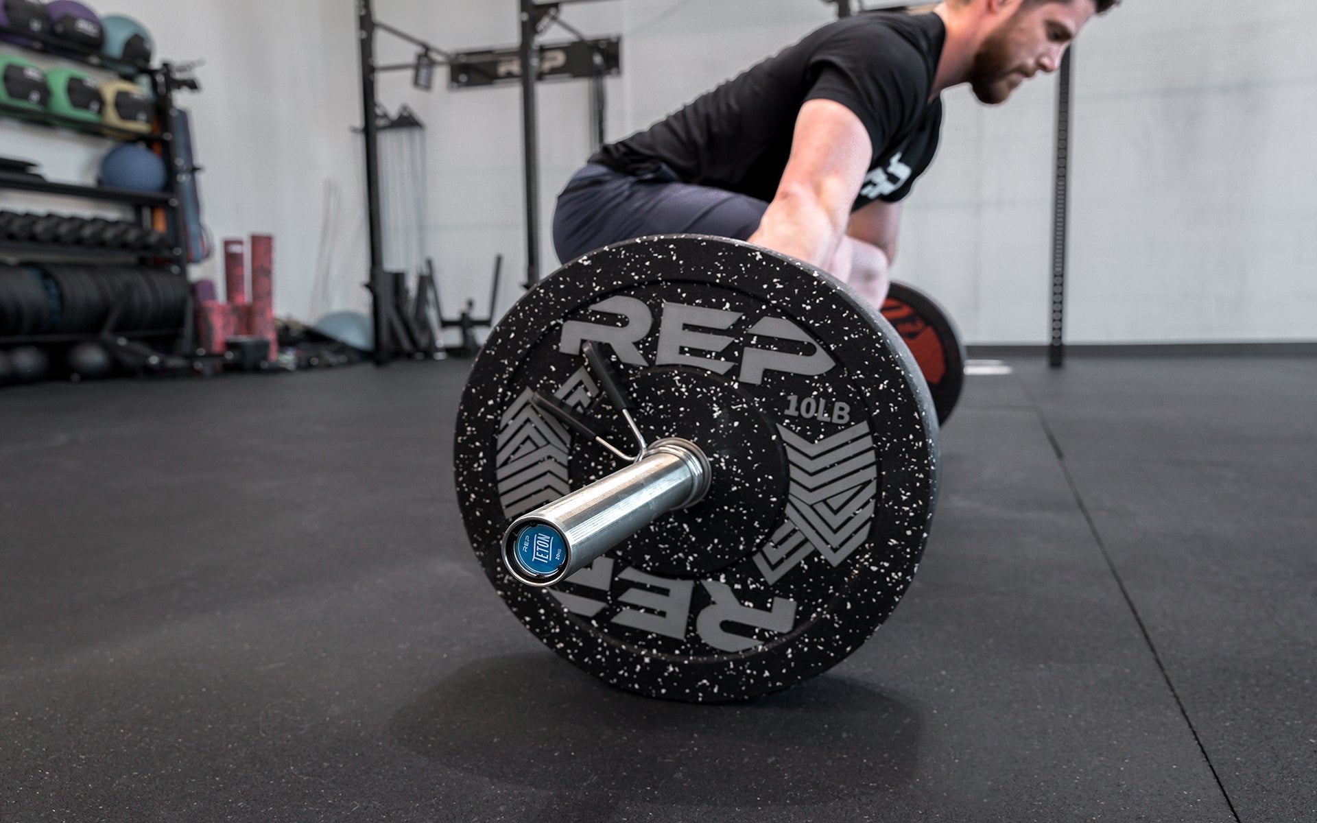 Side view of a male lifter setting up to perform a snatch with a loaded REP Teton Training Bar - 20kg.