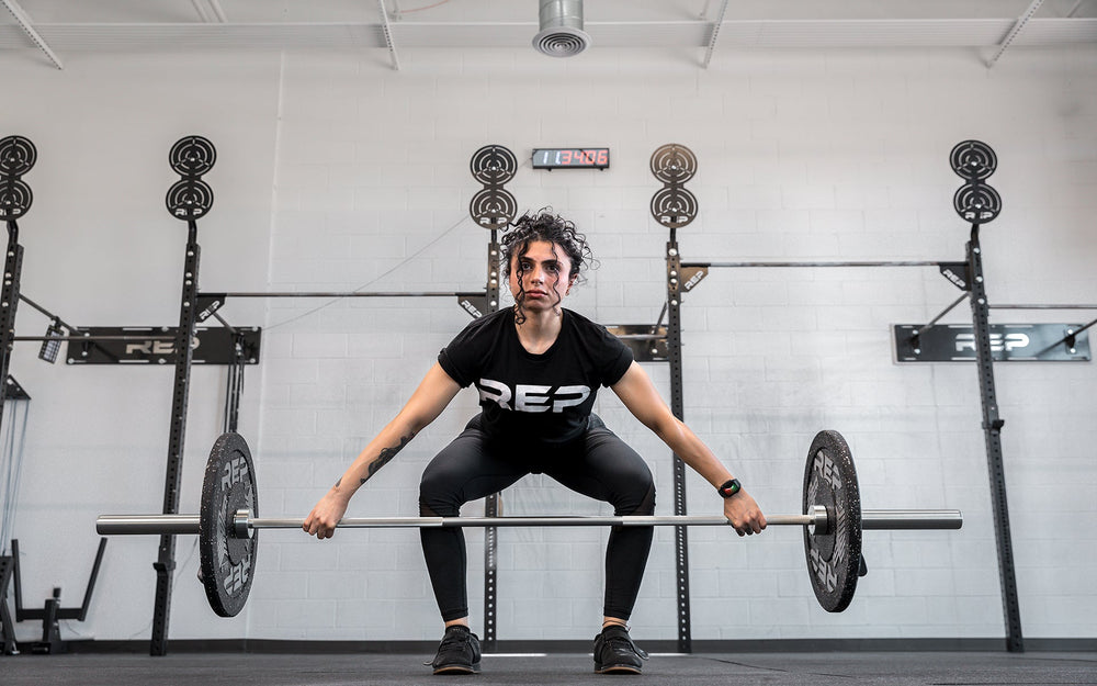 Athlete performing a snatch with the REP 15kg Teton Training Bar.