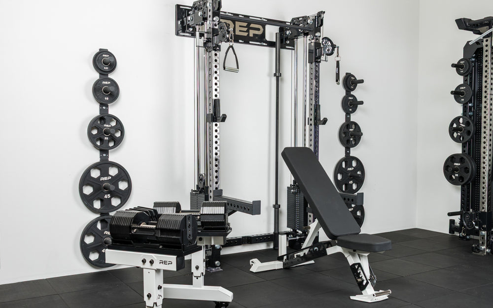 The REP Fitness Compact Home Gym Setup with the Wall-Mounted Athena, Nighthawk adjustable bench, and Equalizer™ Urethane-Coated Plates
