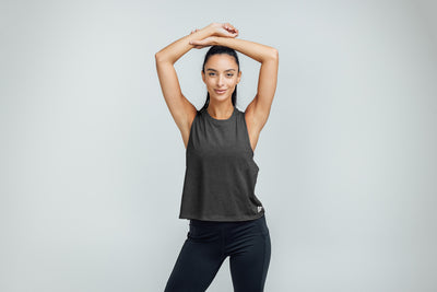 Woman wearing Heather Charcoal/White Peak Cropped Dual-Blend Tank with Leggings