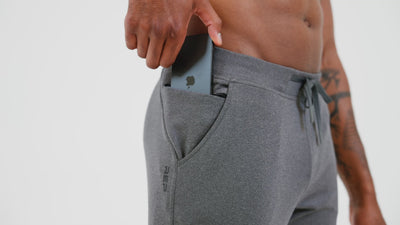 An athlete adjusting their grey Men's Attis Joggers