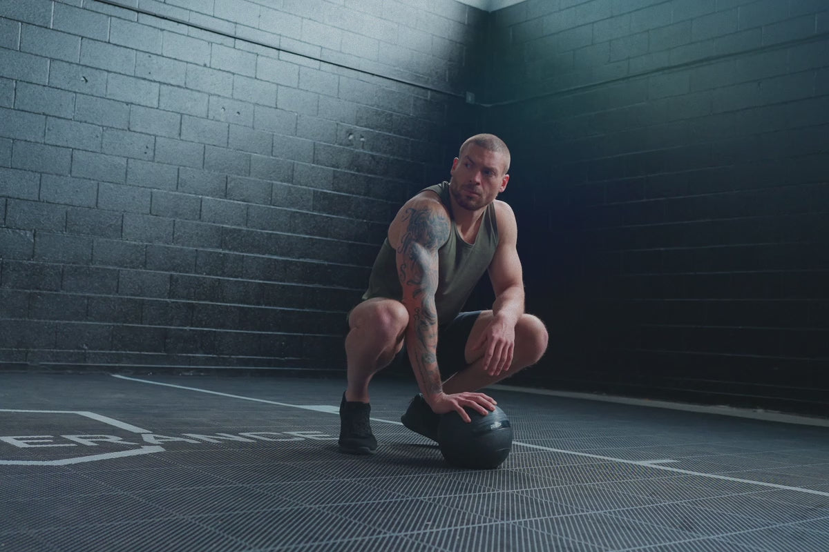 Athlete using a slam ball in the black Men’s Motus Shorts