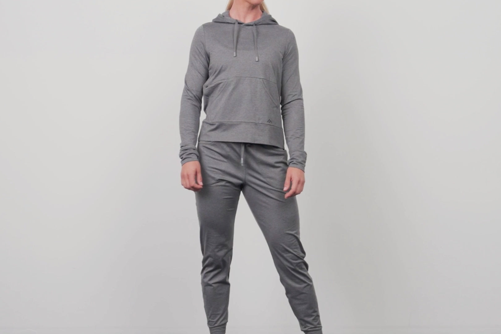 An athlete posing while wearing the grey Women's Vellus Joggers