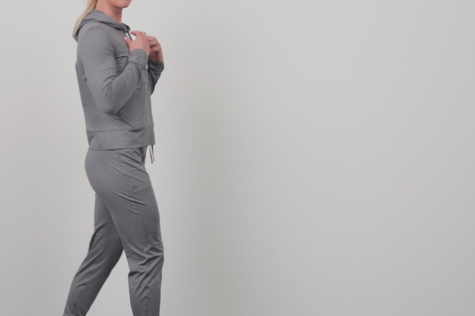 An athlete adjusting their Women's Vellus Joggers in grey