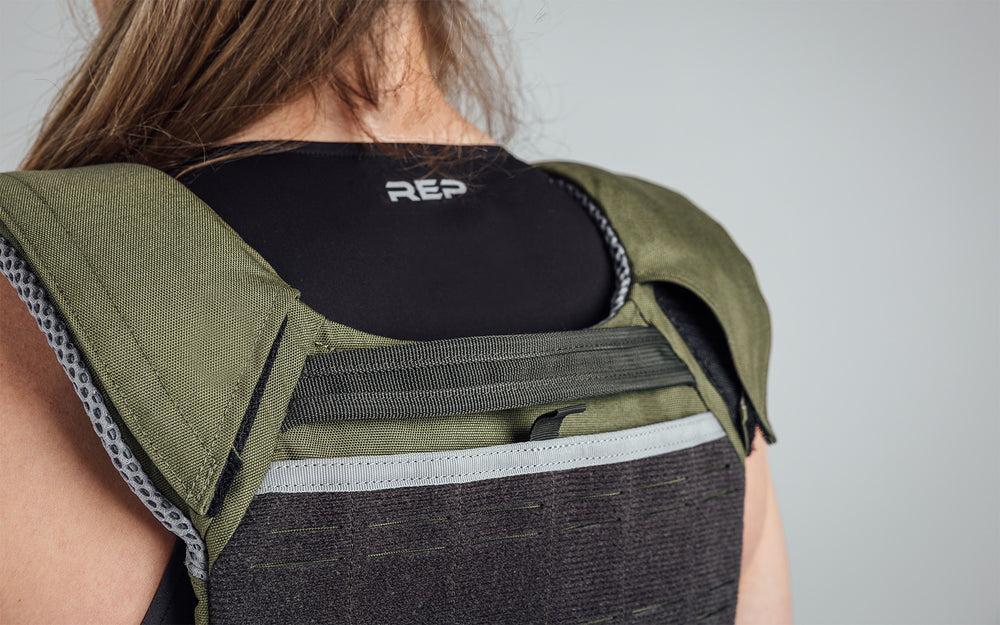 Athlete wearing the olive Strata Weight Vest, view of back top part of vest