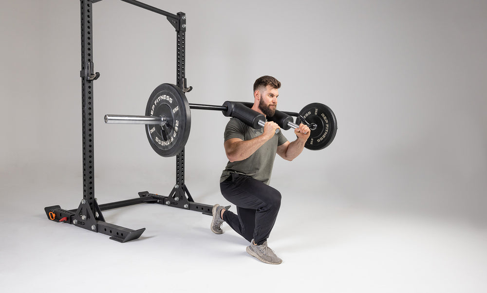 Lifter performing a lunge with a weighted Safety Squat Bar.