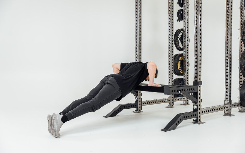 Utility Seat Installed on Spotter Arms on Power Rack Being Used For Incline Push-Ups