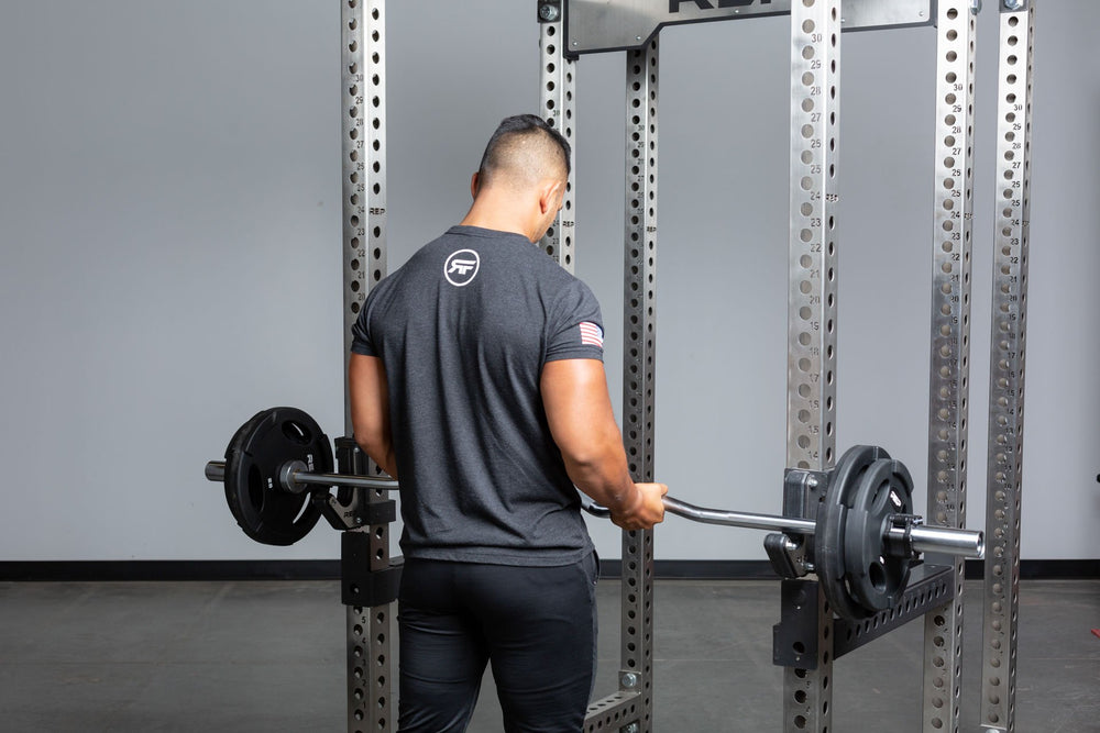 Lifter taking loaded rackable curl bar off of j-cups on a PR-5000 rack.