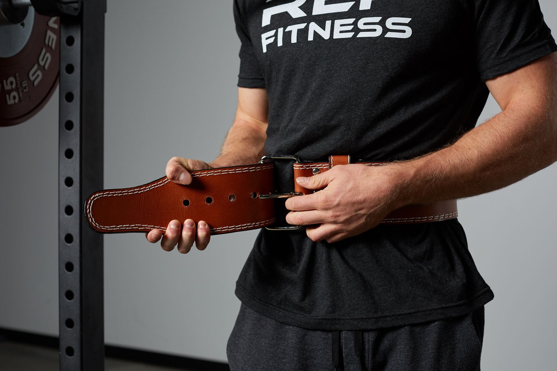 Lifter buckling the REP Lifting Belt around his waist.
