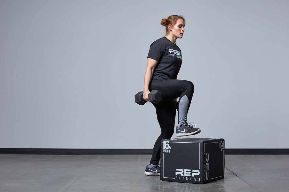 Individual performing weighted box step-ups on the Small REP 3-in-1 Soft Plyo Box.