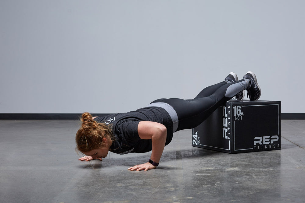 Individual performing decline push-ups on the Medium REP 3-in-1 Soft Plyo Box.