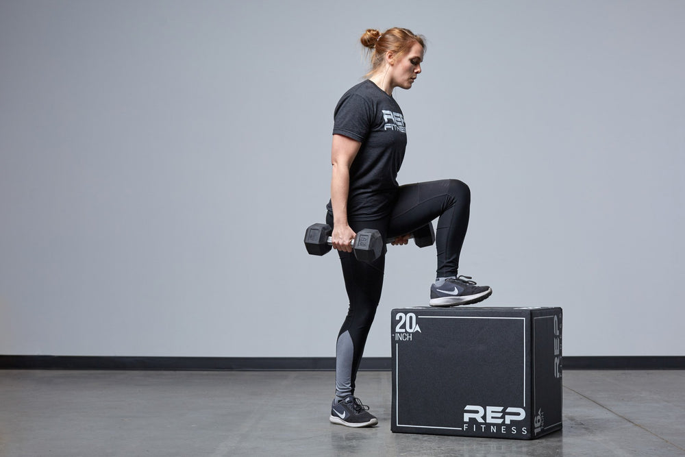 Individual performing weighted box step-ups on the Medium REP 3-in-1 Soft Plyo Box.