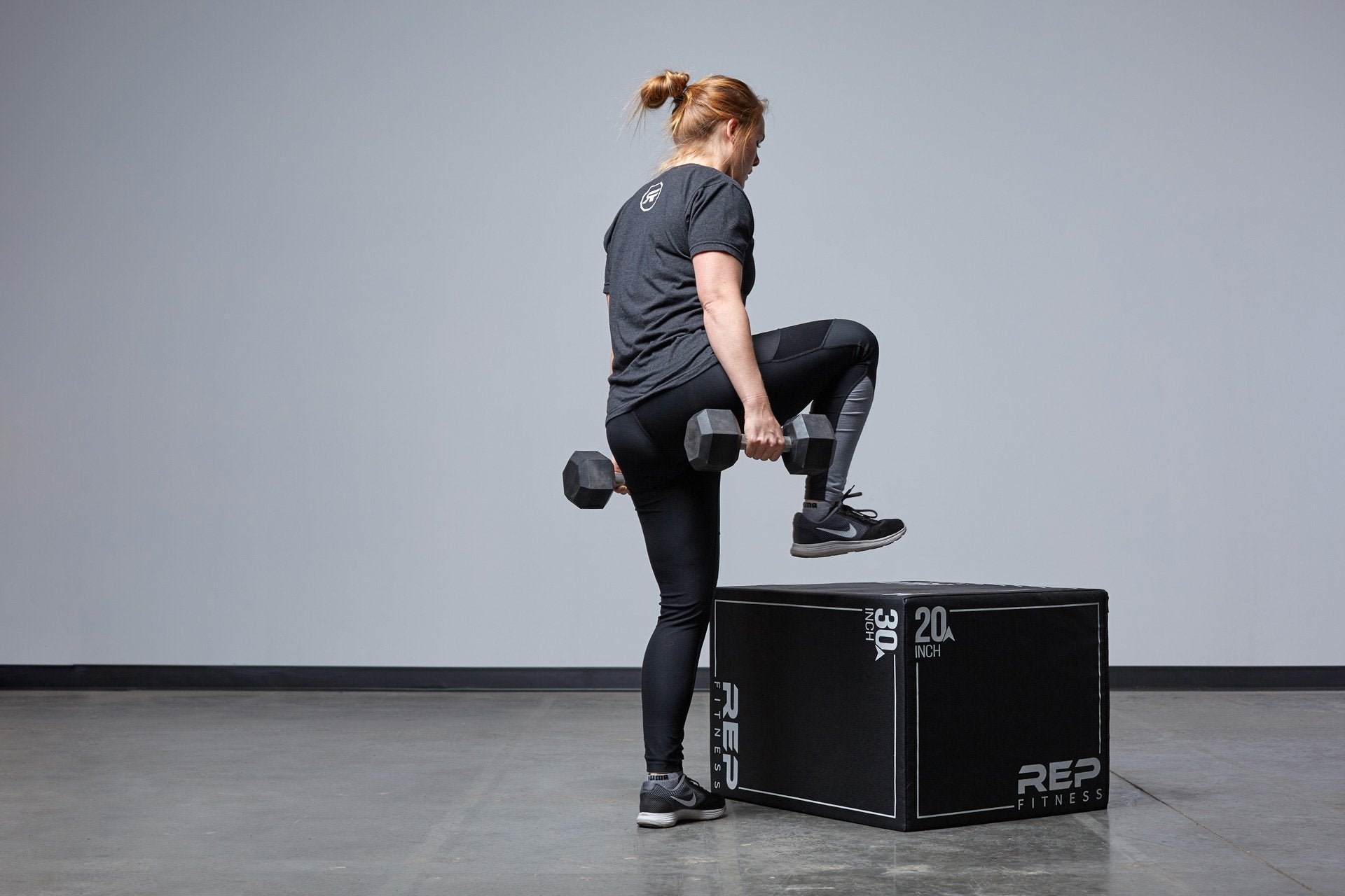 Individual performing weighted box step-ups on the Large REP 3-in-1 Soft Plyo Box.