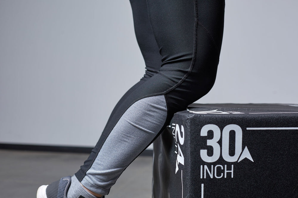 Close-up view of an individual's shins making contact against a Large REP 3-in-1 Soft Plyo Box. The soft plyo box protects against scrapes from failed box jumps.