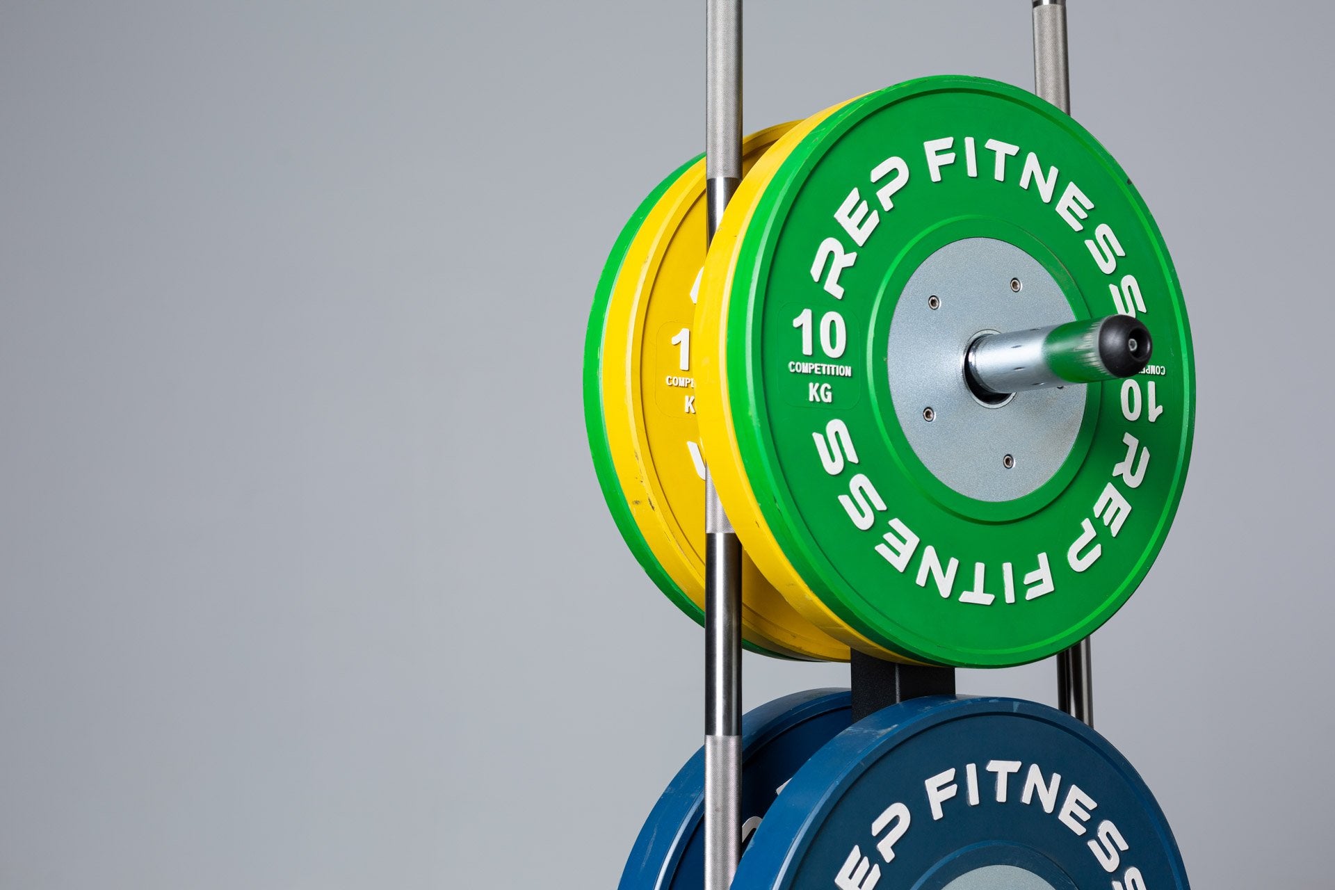 Close-up view of the top section of the REP Bar and Weight Plate Tree loaded with a pair of 10kg REP Competition Bumper Plates and two barbells.