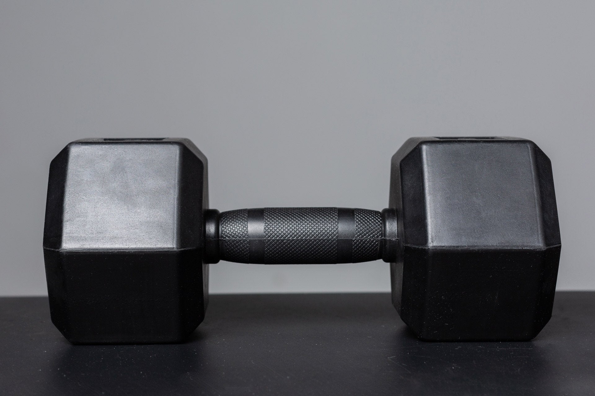 Side view of a Rubber Coated Hex Dumbbell showing the hexagon heads and the center-knurled ergonomic handle.