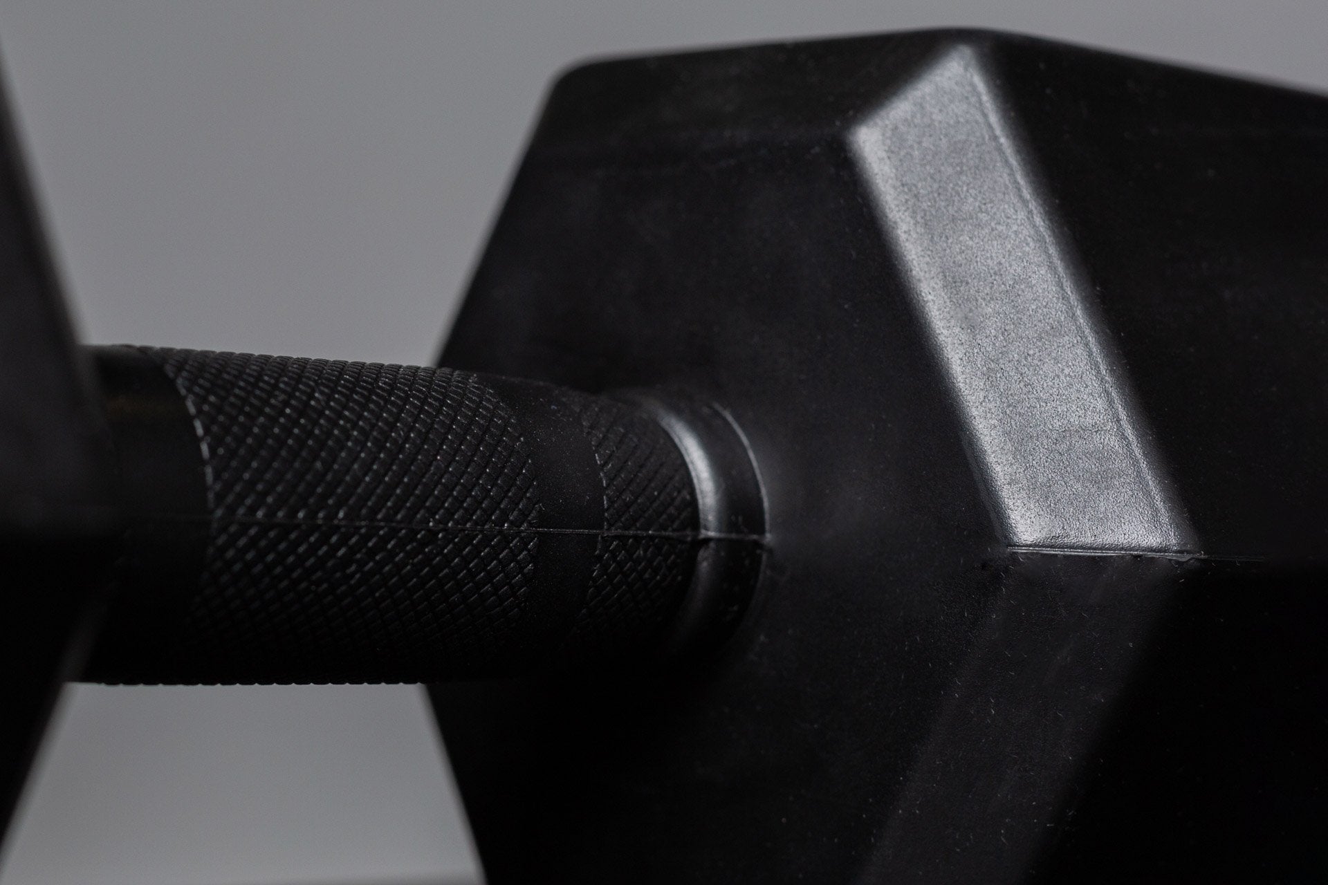 Close-up view of the center-knurled ergonomic handle of a Rubber Coated Hex Dumbbell.