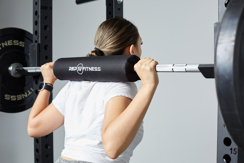 Lifter using the REP barbell shoulder pad for comfort while back squatting.