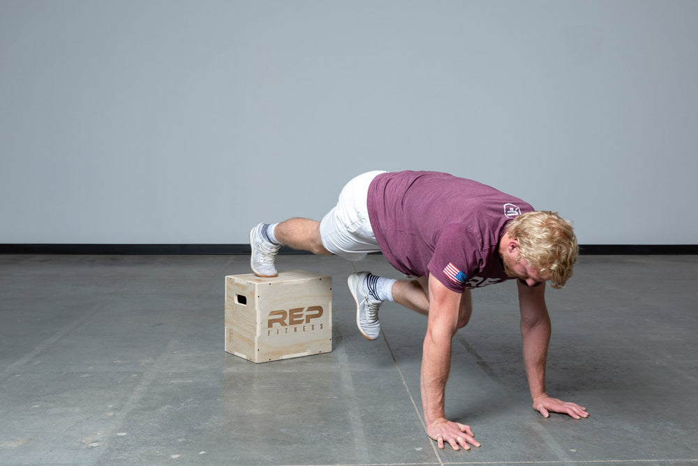 Lifter performing single leg plank on a Small REP 3-in-1 Wood Plyo Box.