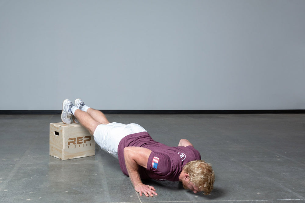 Lifter performing decline push-ups on a Small REP 3-in-1 Wood Plyo Box.