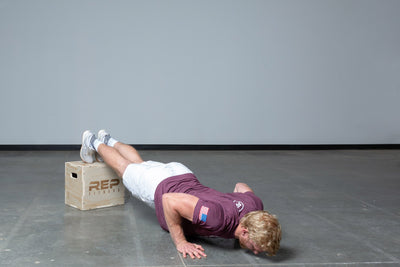 Lifter performing decline push-ups on a Small REP 3-in-1 Wood Plyo Box.