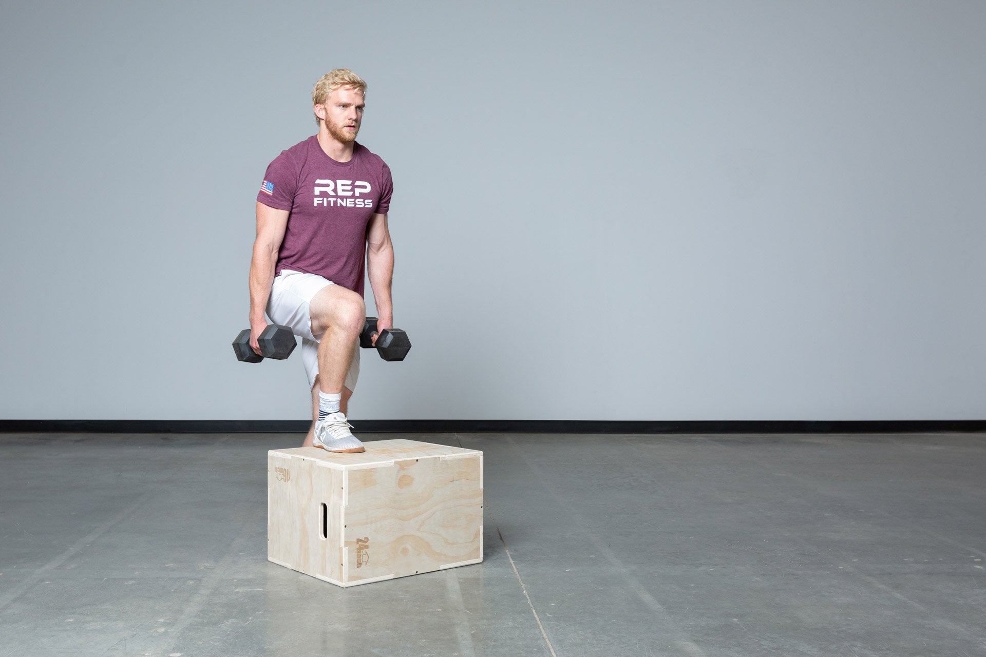 Lifter performing weighted step-ups on a Medium REP 3-in-1 Wood Plyo Box.