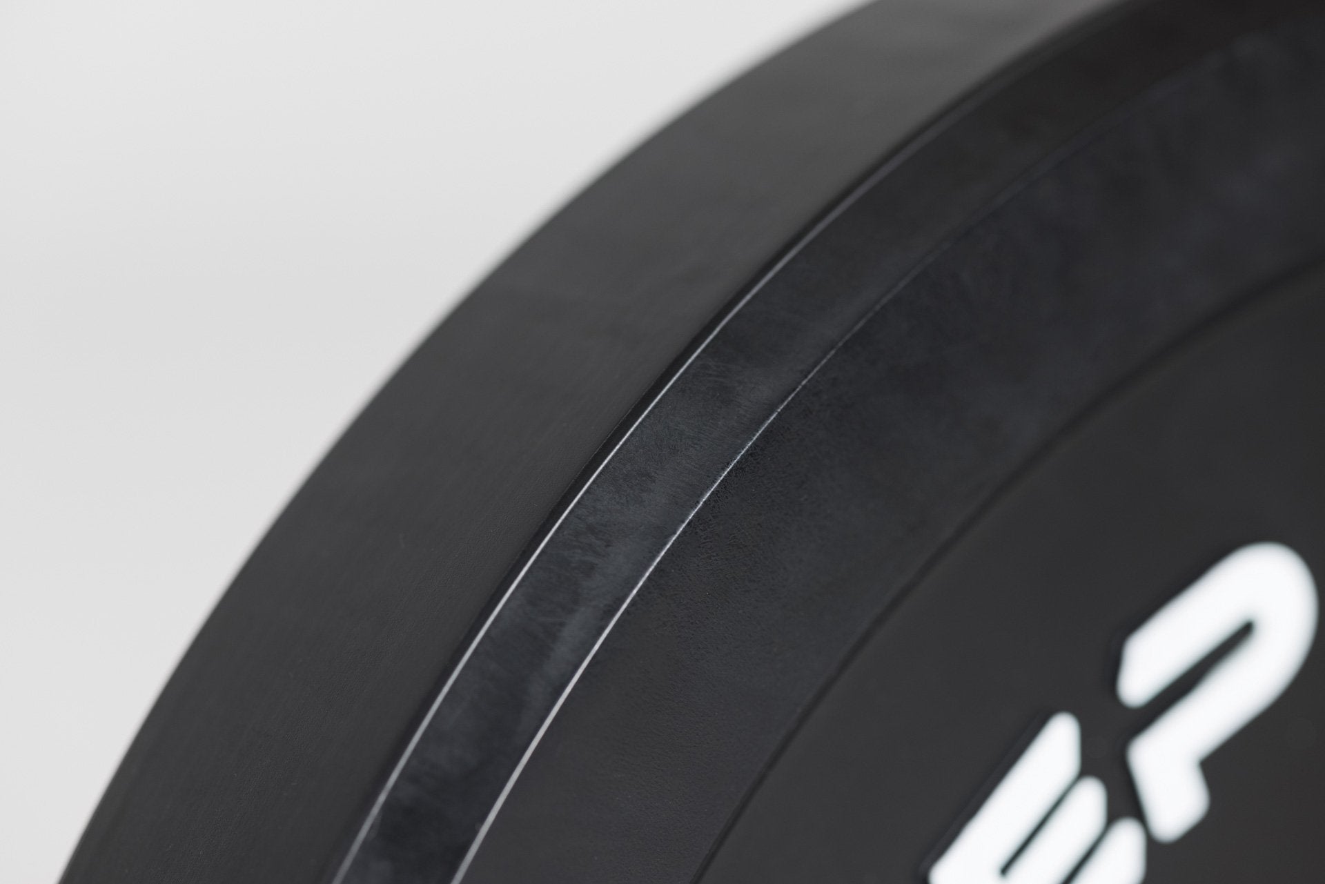 Close-up view of beveled edge feature which makes REP's Black Bumper Plates easier to pick up off the floor.