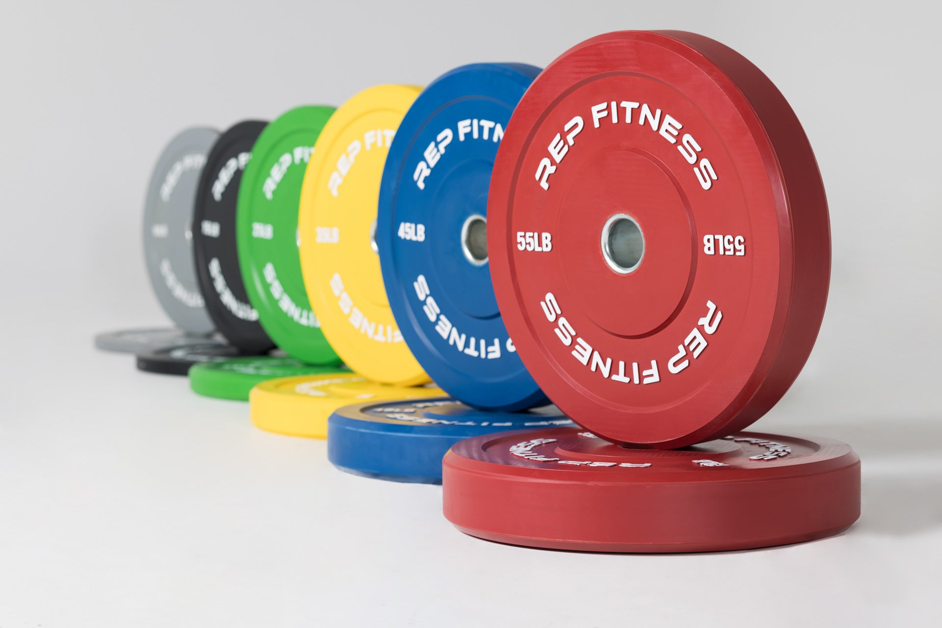 Full set of Color Bumper Plate Pairs: gray 10, black 15, green 25, yellow 35, blue 45, and red 55lb pairs.