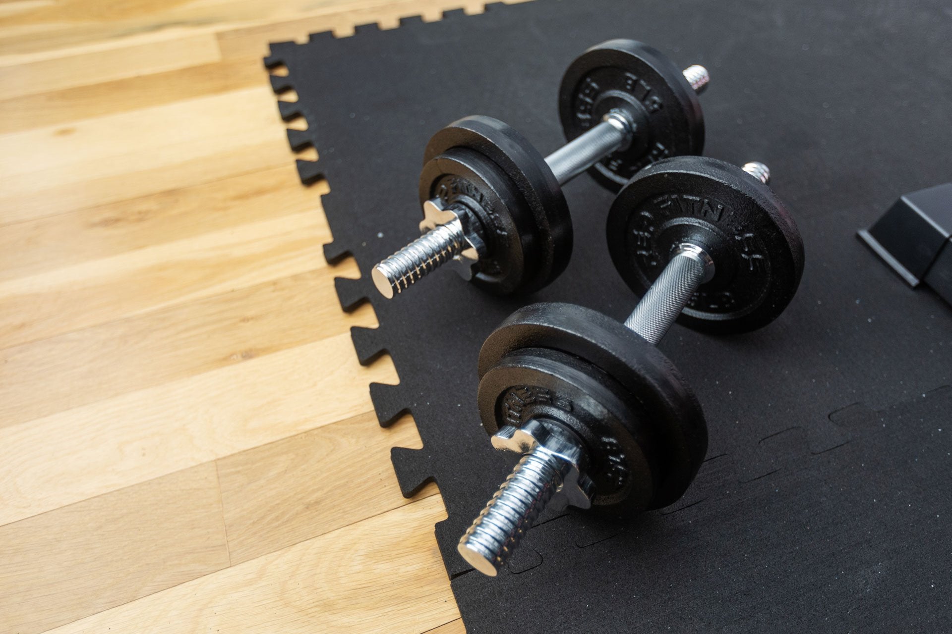 Close-up view of a pair of Adjustable Dumbbells loaded with 30lbs of weight.