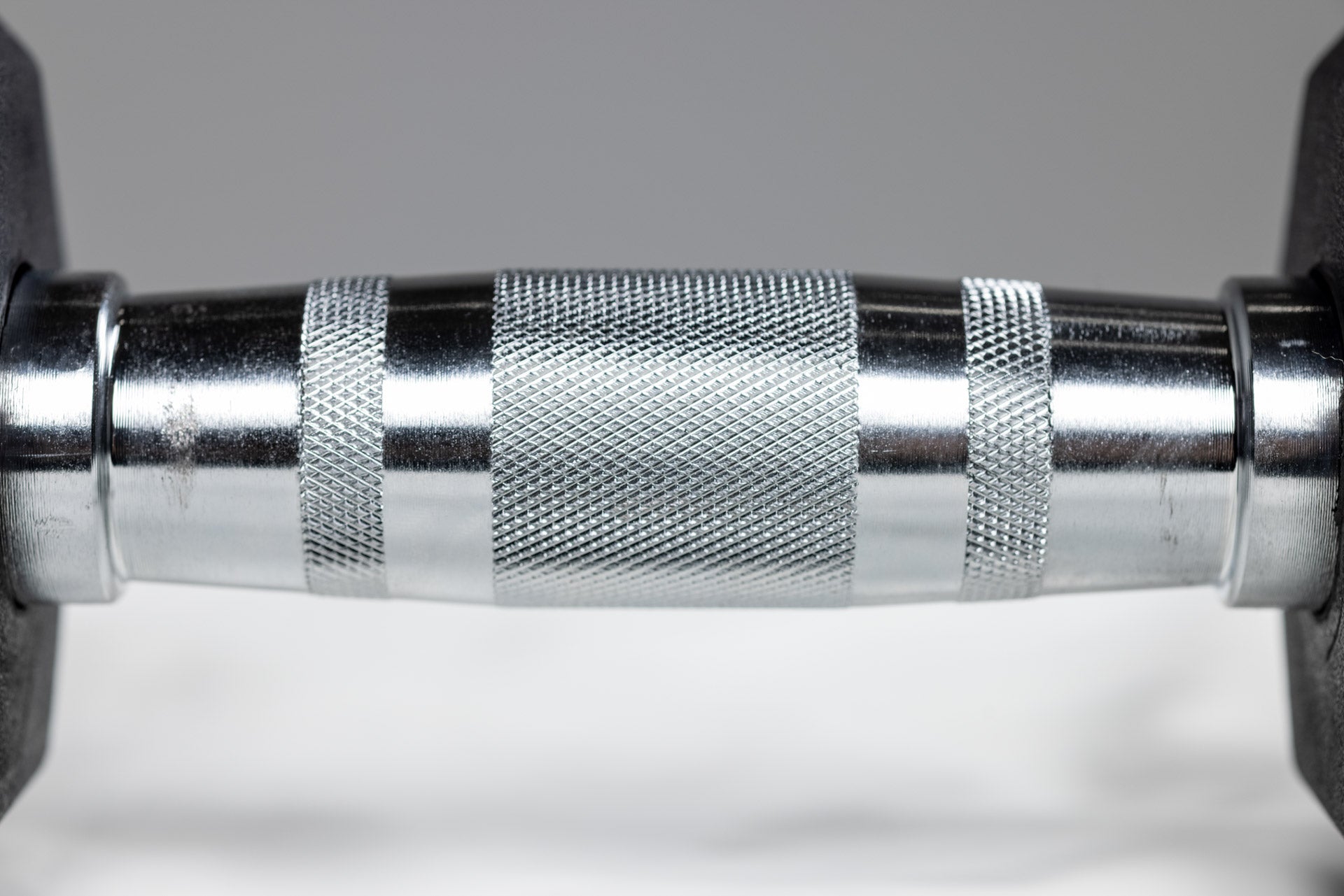 Close-up view of the knurled ergonomic handle of a REP Ergo Hex Dumbbell.