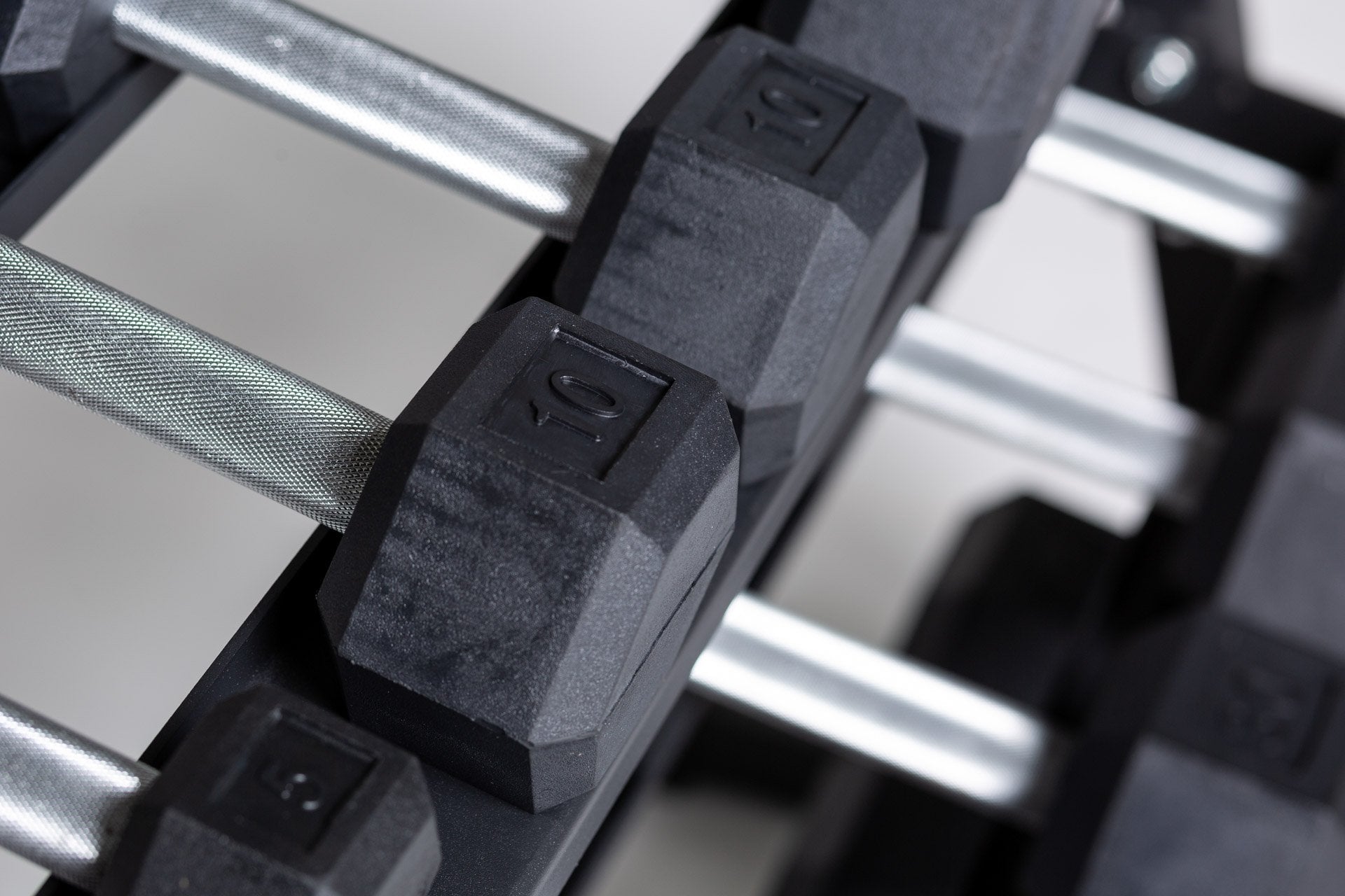 Close-up above view of the 10lb pair of a 5-50lb Hex Dumbbell Set being stored on the top shelf of a REP Dumbbell Rack.