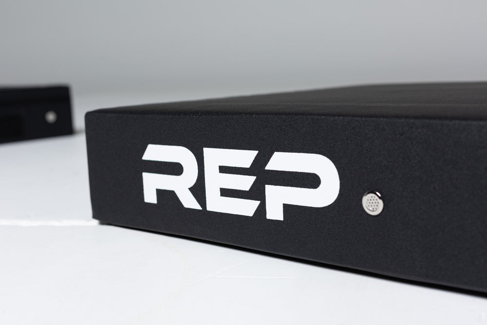 Close-up view of the white "REP" logo and an exhaust vent featured on the side of a REP Crash Pad.